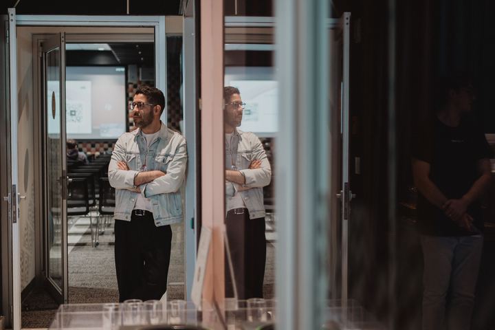 Adrian Sanchez Castro waiting by the glass doors as the room fills.